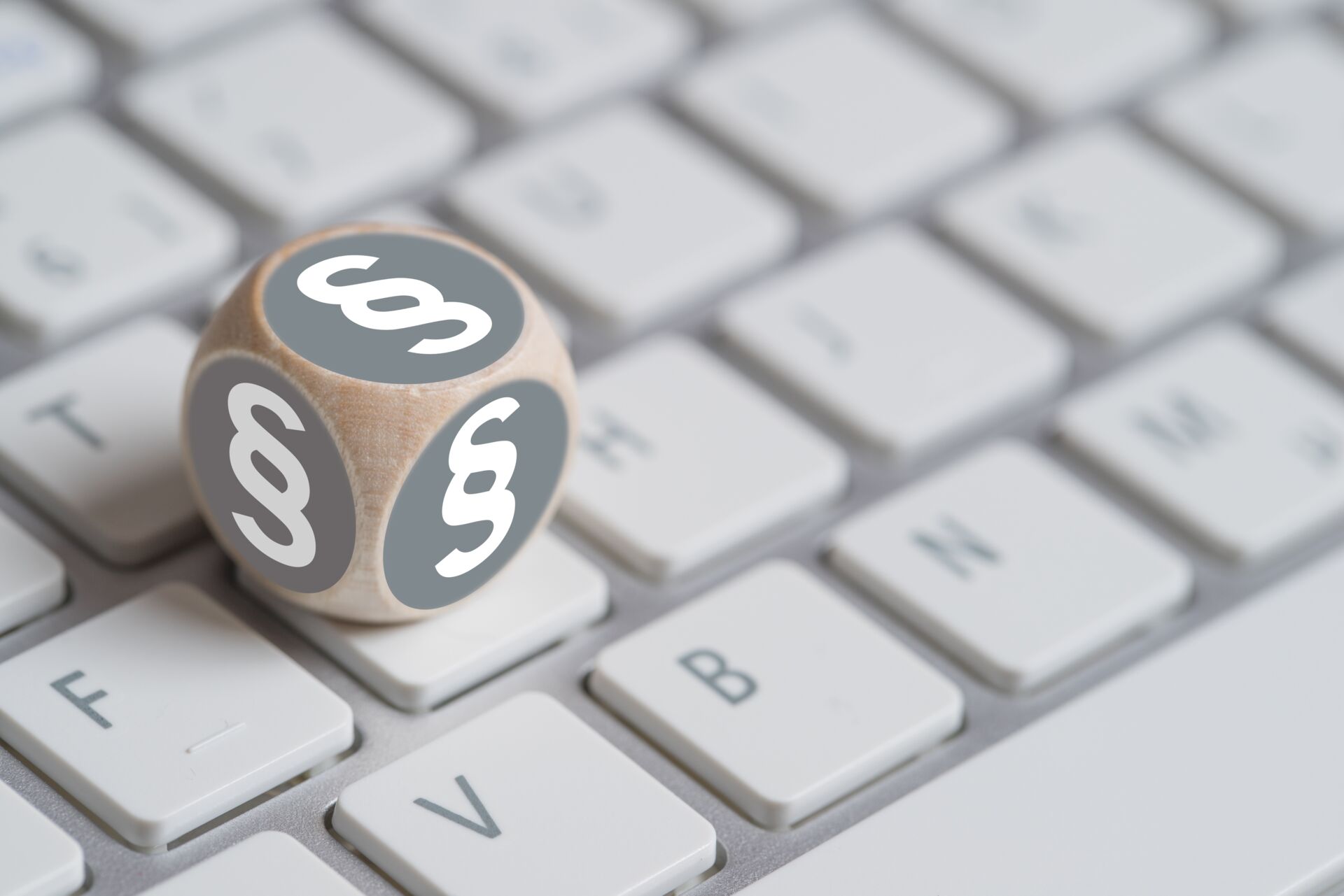 Ein Würfel mit Paragraphenzeichen liegt auf einer Tastatur