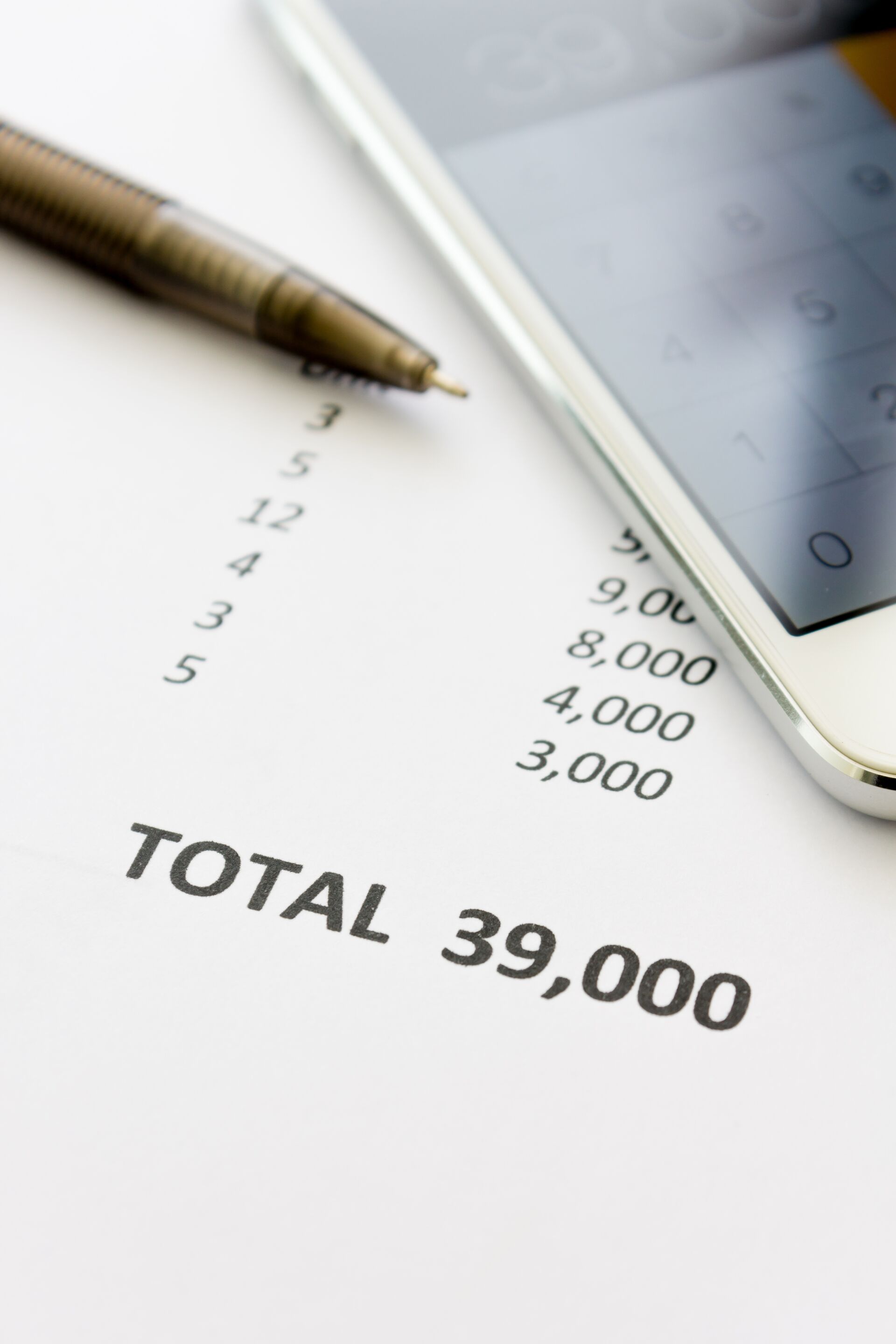 Ein Bild einer Rechnung mit dem Betrag "TOTAL 39.000", einem Stift und einem Telefon